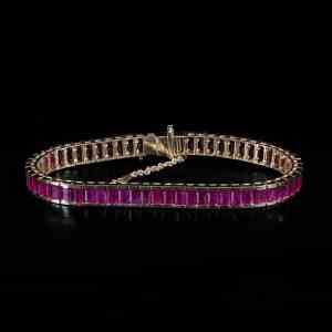 Luxury 18K yellow gold tennis bracelet featuring natural step-cut Burmese rubies with GIA certification confirming Myanmar origin.