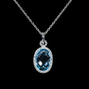 18K white gold pendant necklace featuring a natural oval blue topaz surrounded by a halo of brilliant-cut diamonds with a matching white gold chain.