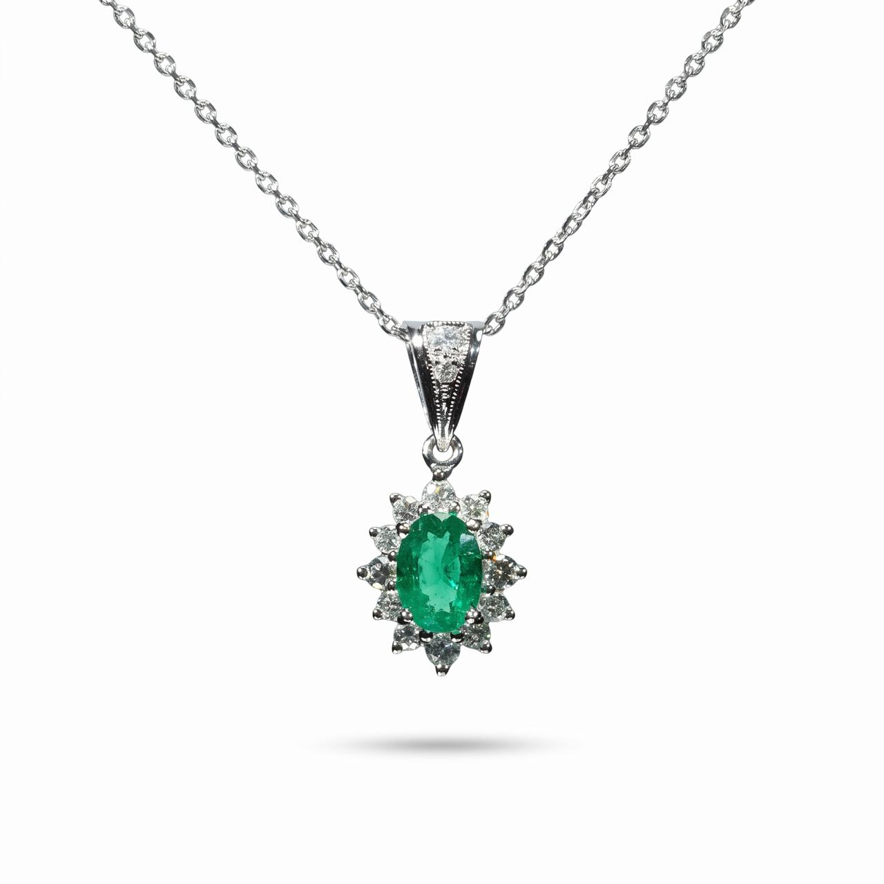 Elegant 18K white gold pendant necklace featuring a natural Colombian emerald surrounded by a halo of brilliant natural diamonds suspended from a matching white gold chain.
