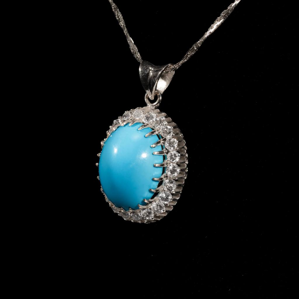 Celeste turquoise halo pendant necklace featuring an oval blue turquoise gemstone with sparkling halo closeup