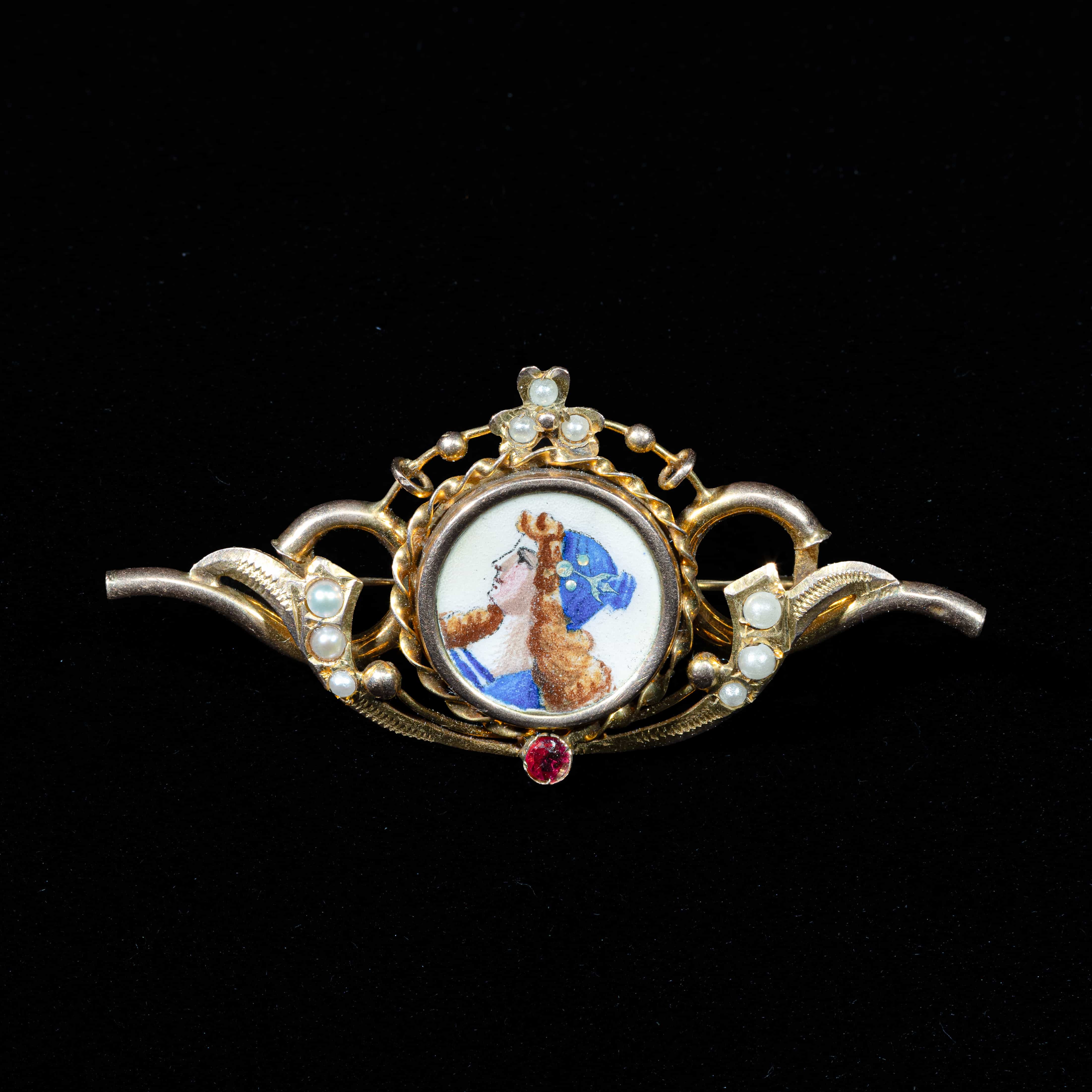 Victorian antique gold brooch featuring an original hand-painted porcelain miniature, natural seed pearls, and a ruby accent.