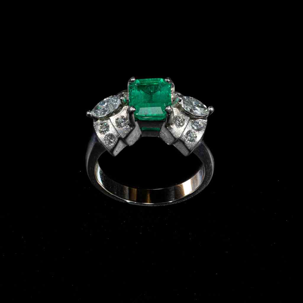 Elegant 18K white gold ring featuring a natural Colombian emerald accented by marquise-cut and round brilliant diamonds.