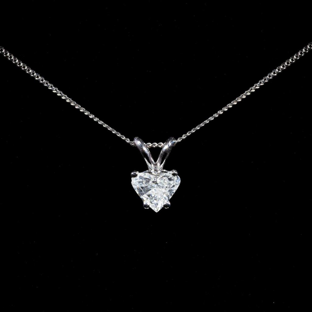 Elegant 14K white gold pendant necklace featuring a 0.65 ct heart-shaped natural diamond in a classic solitaire setting with a matching gold chain.