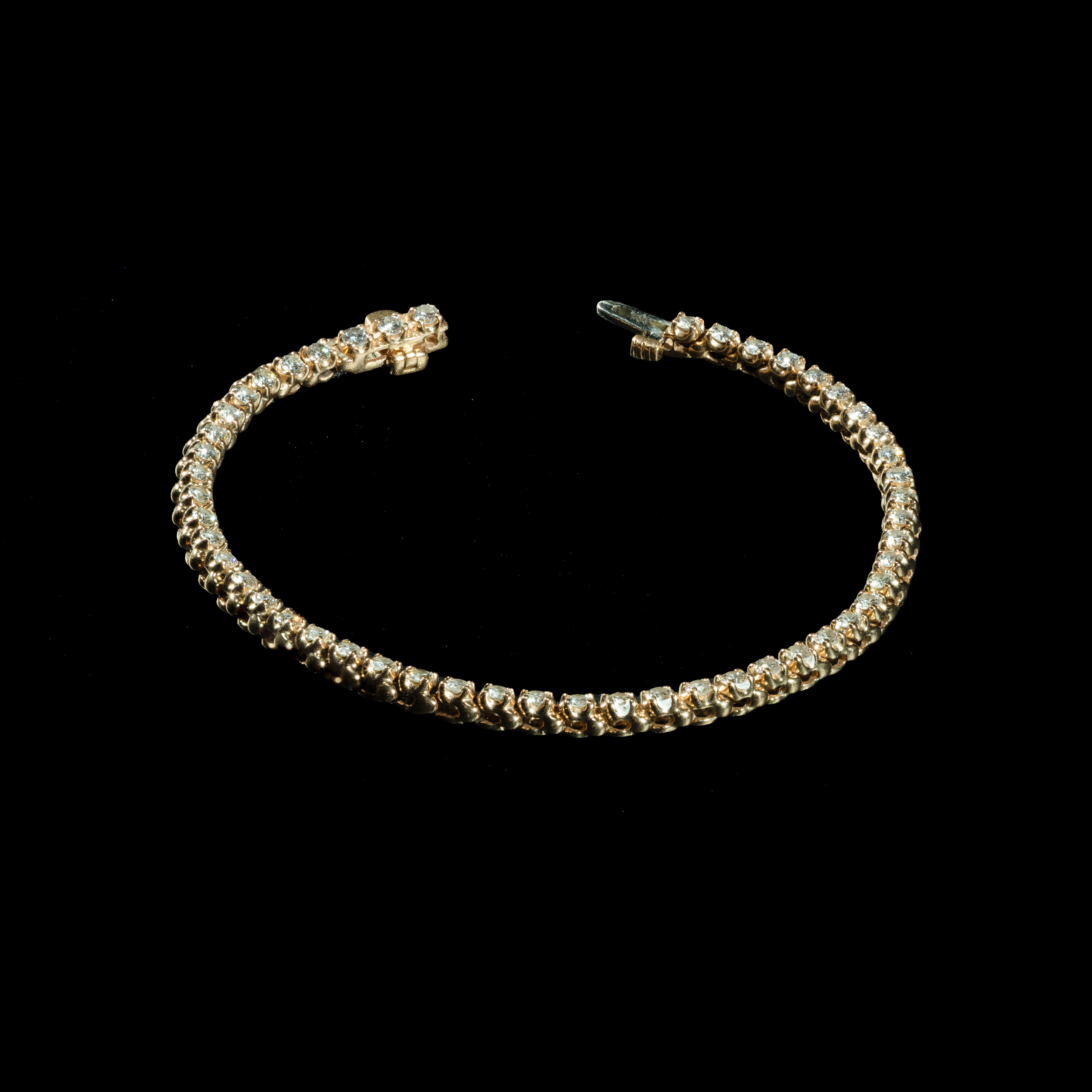 Elegant 14K yellow gold tennis bracelet featuring 47 natural round brilliant-cut diamonds.