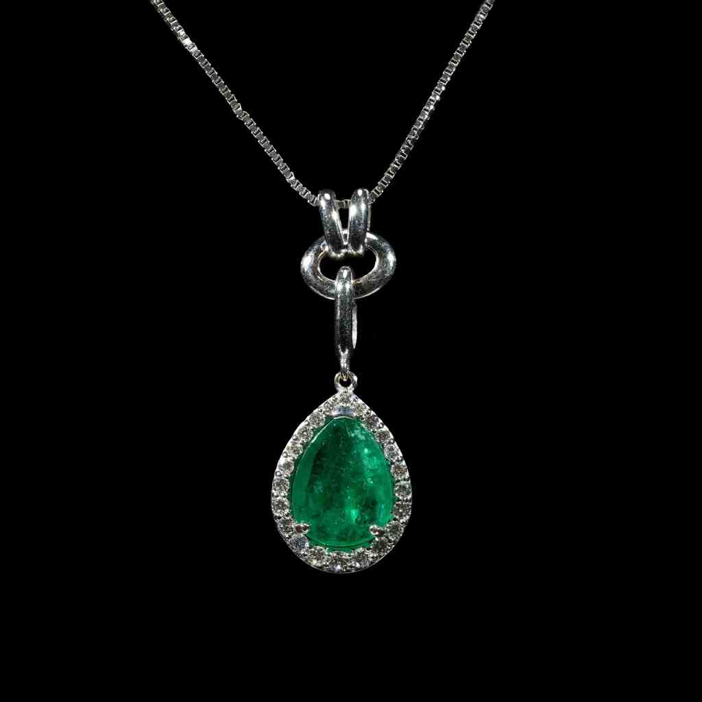 white gold pendant necklace featuring a 1.21 ct natural Colombian emerald accented by a 0.39 ct pear-shaped diamond on a delicate white gold chain.