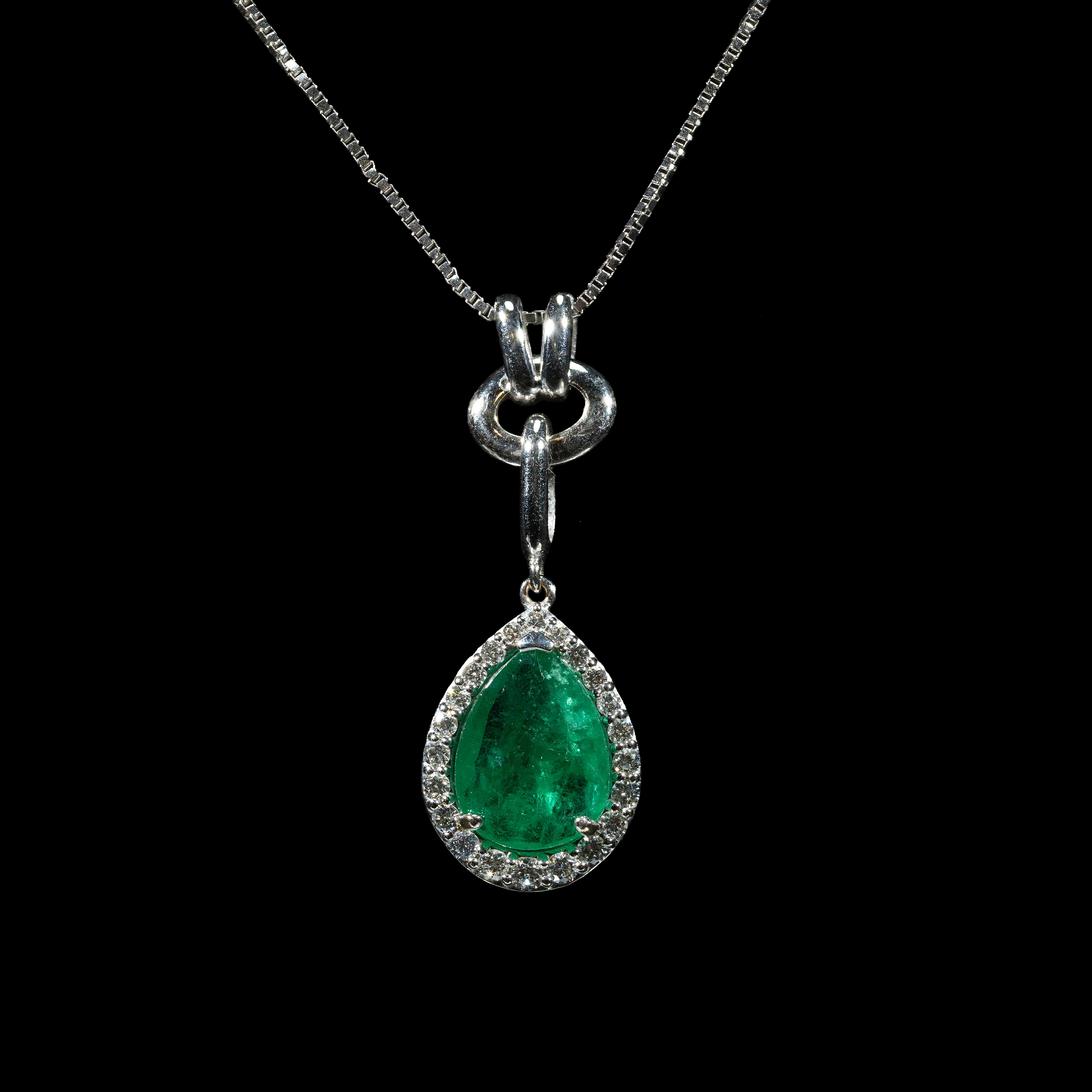 white gold pendant necklace featuring a 1.21 ct natural Colombian emerald accented by a 0.39 ct pear-shaped diamond on a delicate white gold chain.