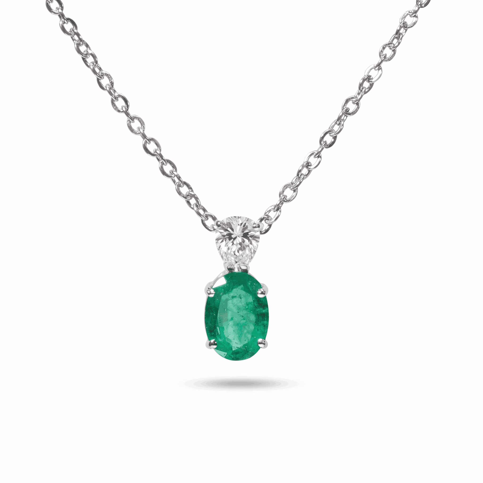 18K white gold pendant necklace featuring a 1.21 ct natural Colombian emerald accented by a 0.39 ct pear-shaped diamond on a delicate white gold chain.