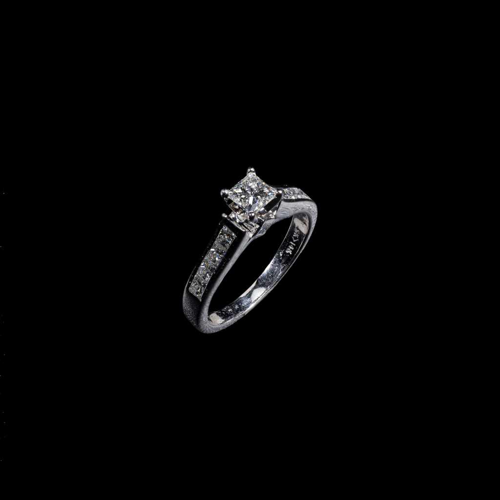 18K white gold solitaire ring with round center diamond and princess-cut diamond band