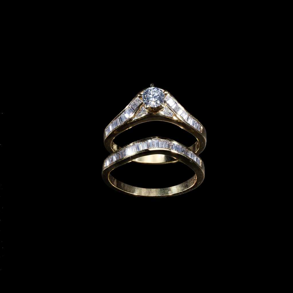 18K yellow gold bridal ring set featuring a 0.35 carat round center diamond and 0.98 carats of baguette-cut diamonds.