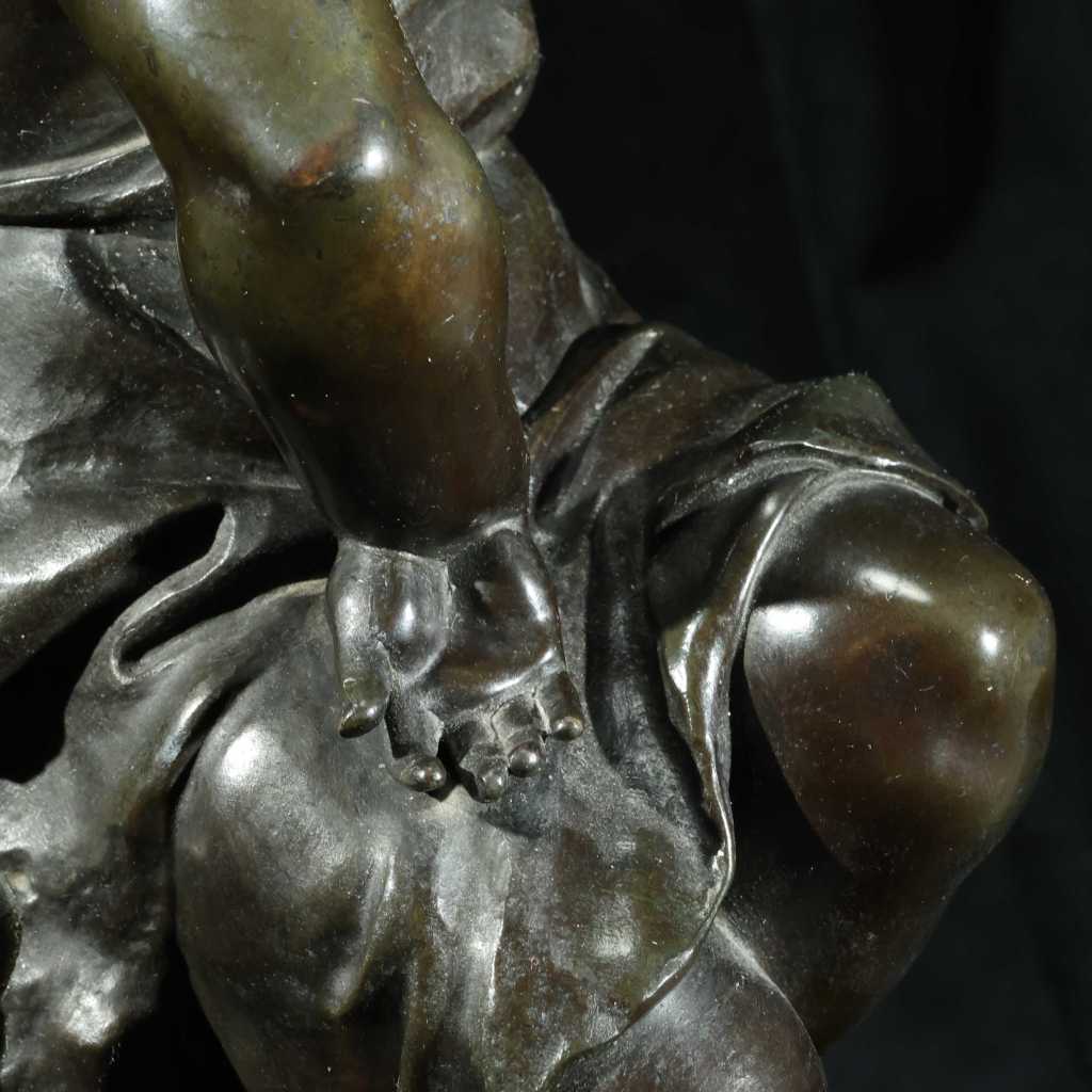Early 20th-century European bronze sculpture of a seated young boy on a stone base