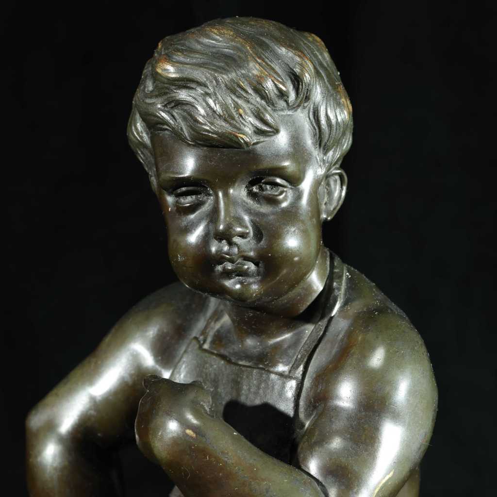 Early 20th-century European bronze sculpture of a seated young boy on a stone base
