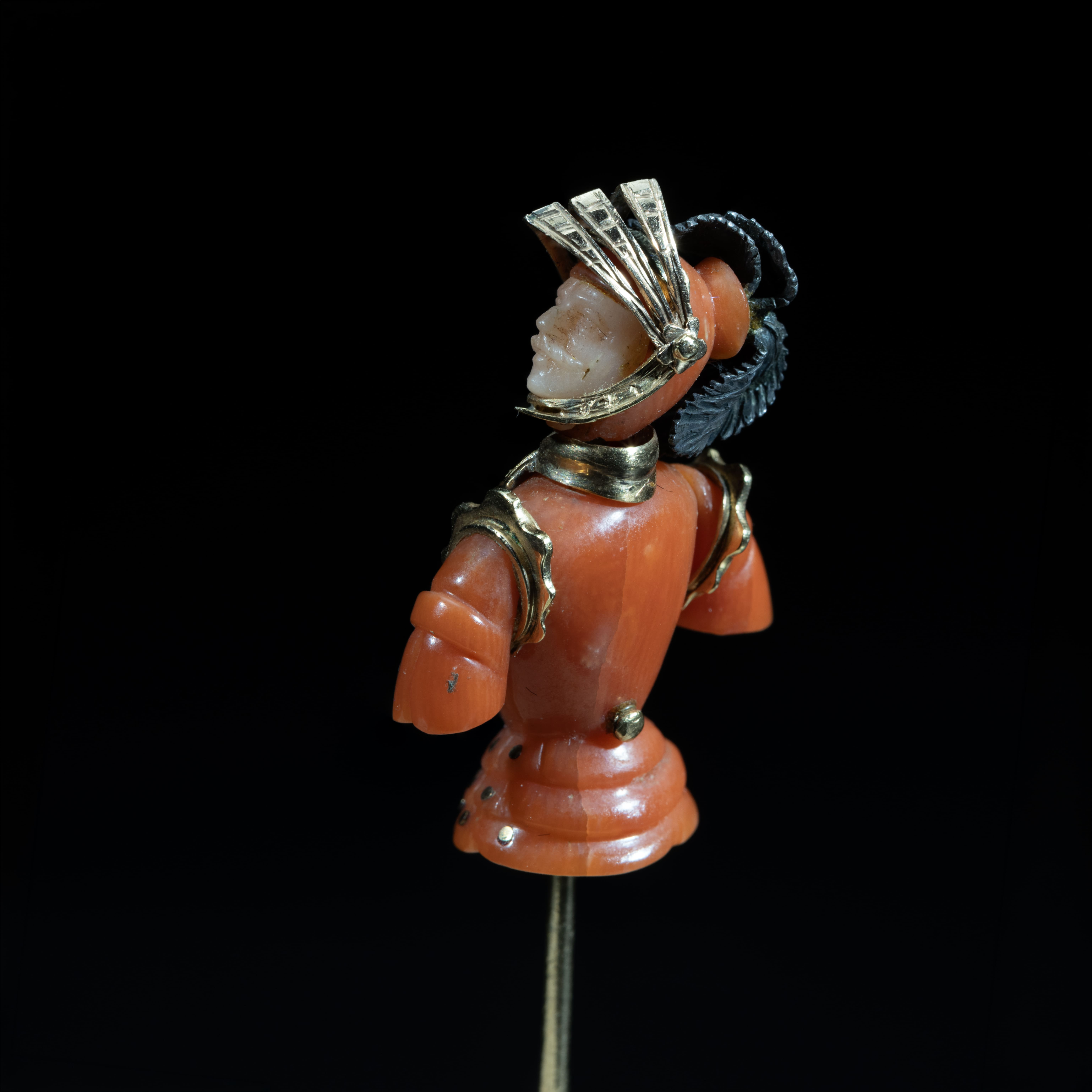 Antique gold and natural coral figural stick pin with intricate sculptural detailing
