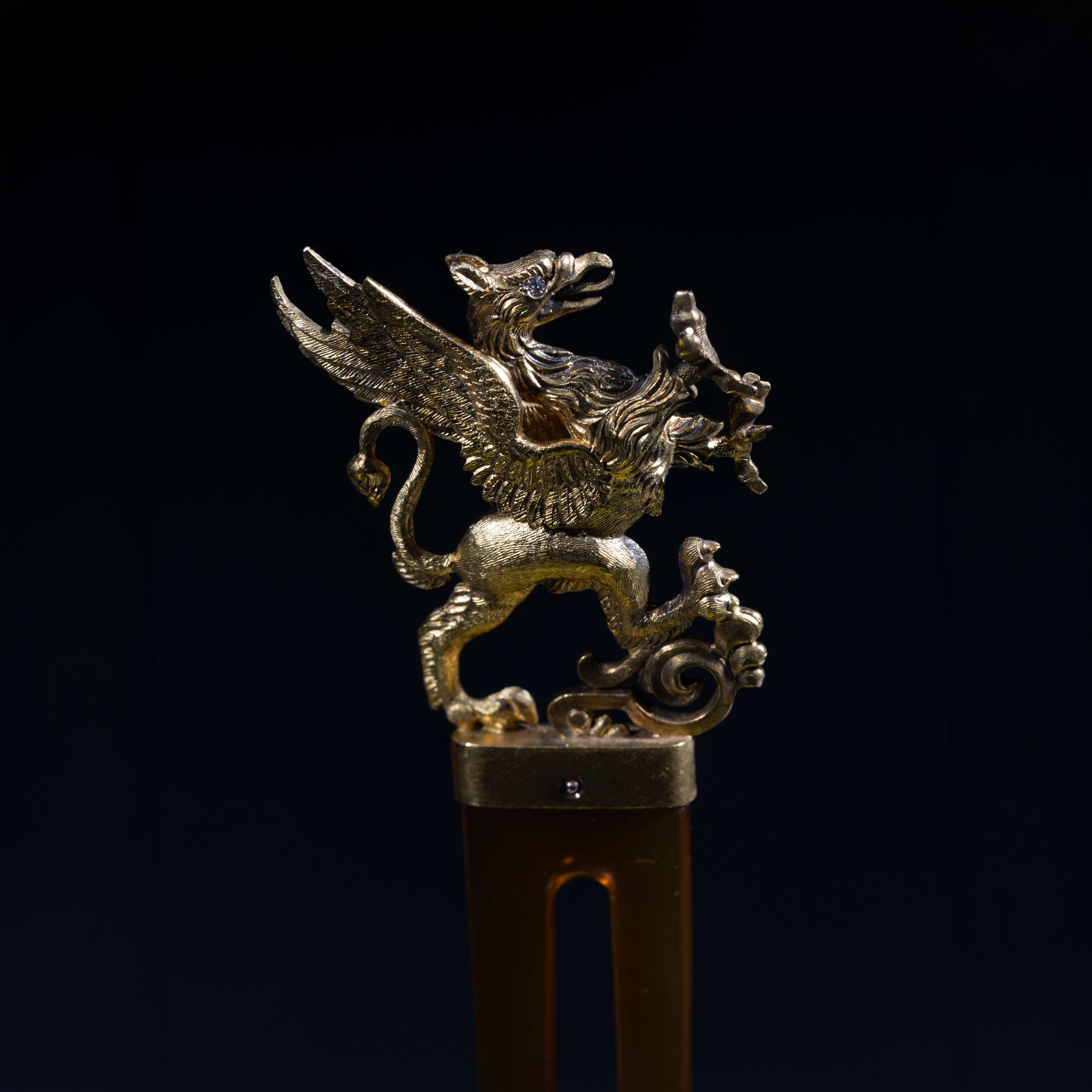 Antique gold winged griffin figural ornament with intricate detailing and jeweled eye