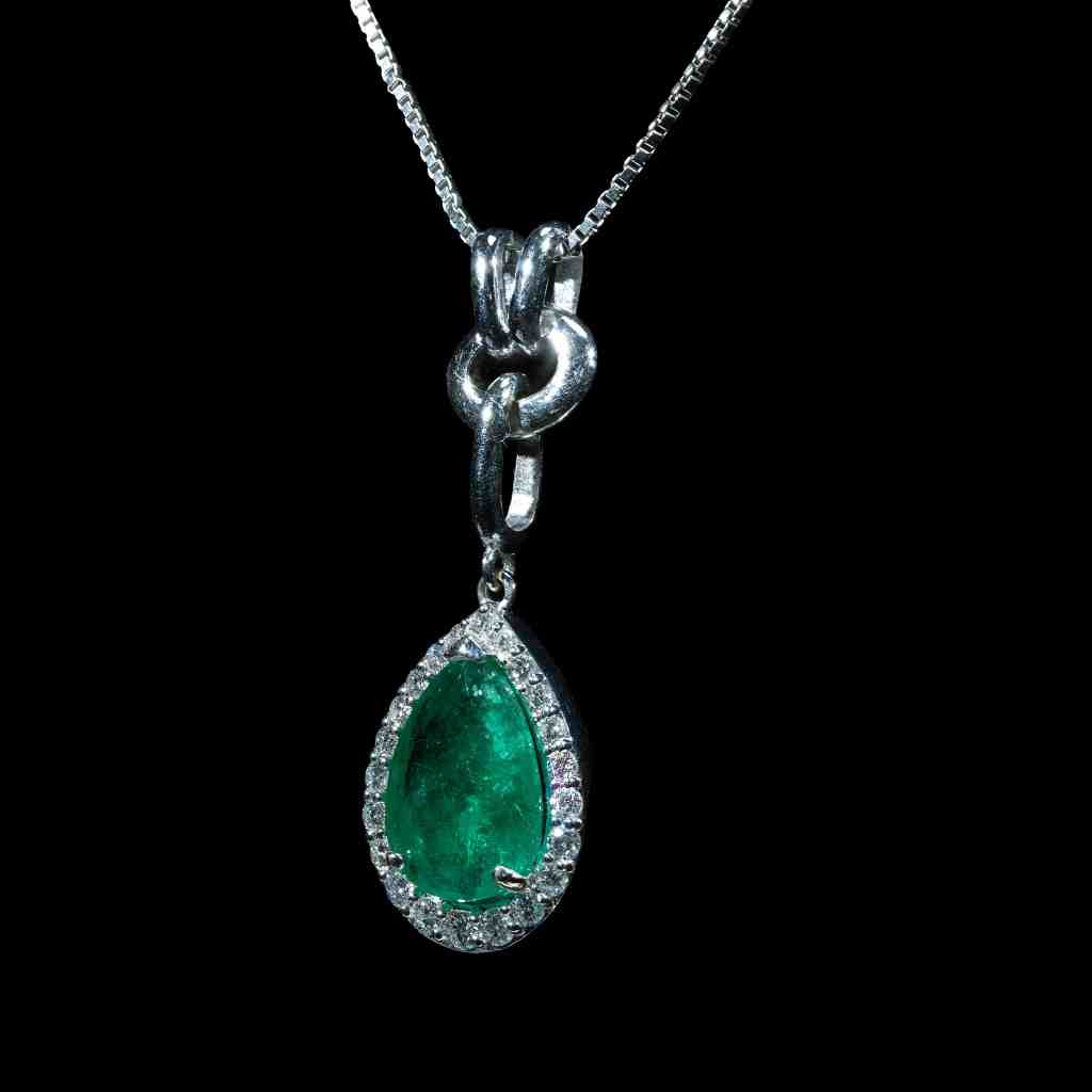 18K gold pendant necklace featuring a 1.21 ct natural Colombian emerald accented by a 0.39 ct pear-shaped diamond on a delicate white gold chain.