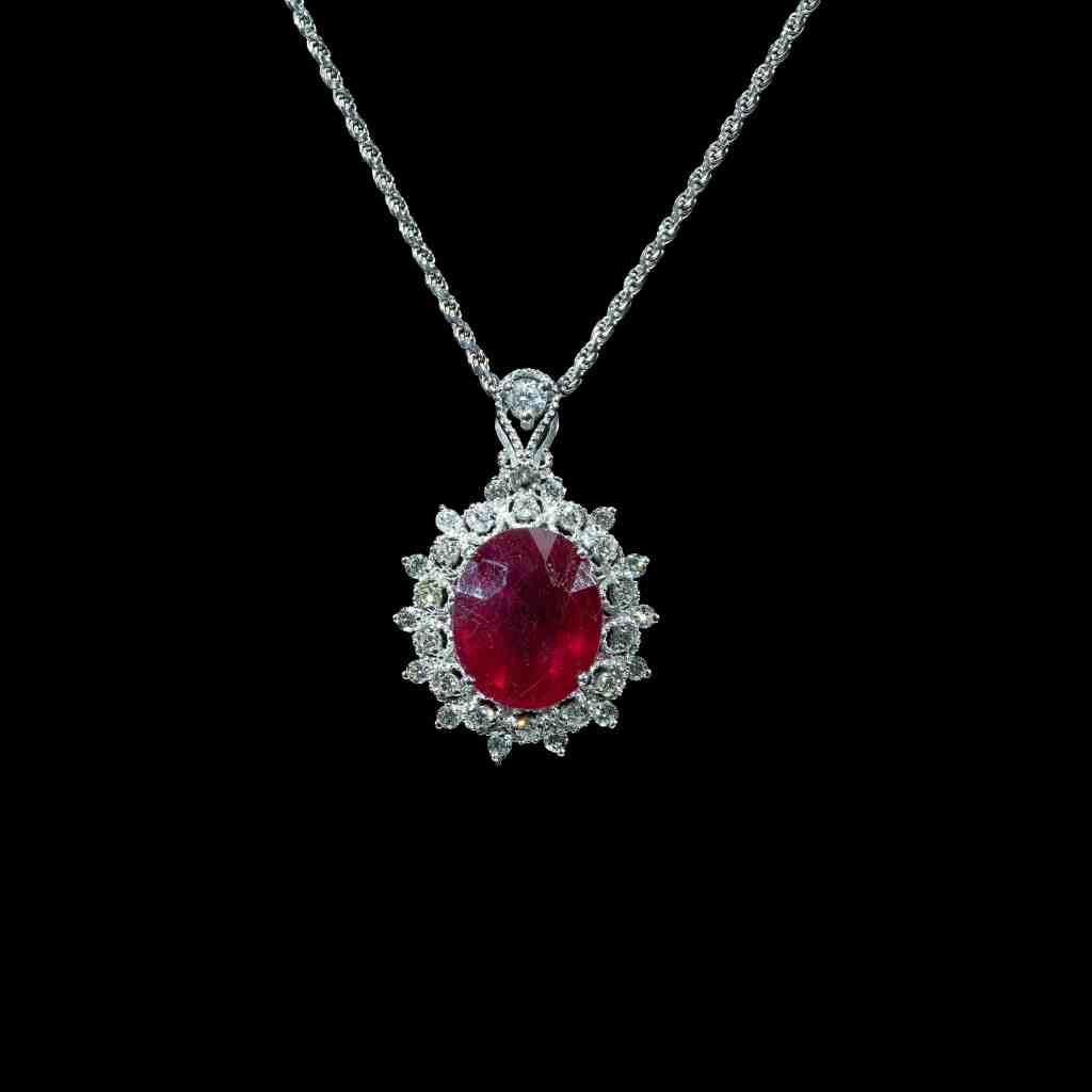18k gold pendant necklace featuring a 0.80 ct natural ruby surrounded by a halo of 0.63 ct brilliant-cut natural diamonds on a white gold chain.