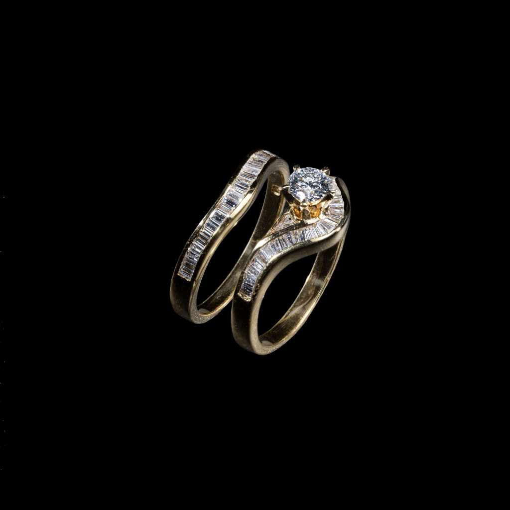 18K yellow gold bridal ring set featuring a 0.35 carat round center diamond and 0.98 carats of baguette-cut diamonds.