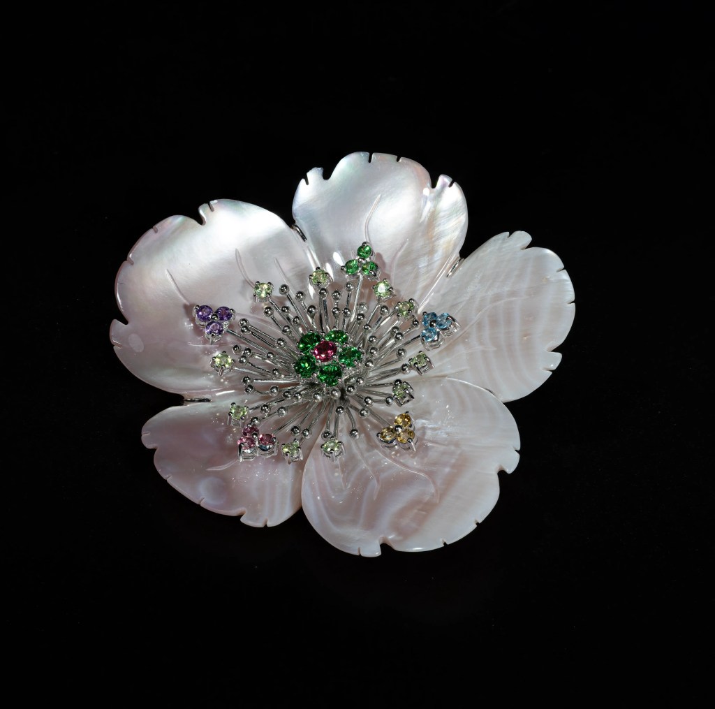 Hand-carved mother-of-pearl flower brooch with vibrant multicolored gemstones and intricate floral detailing