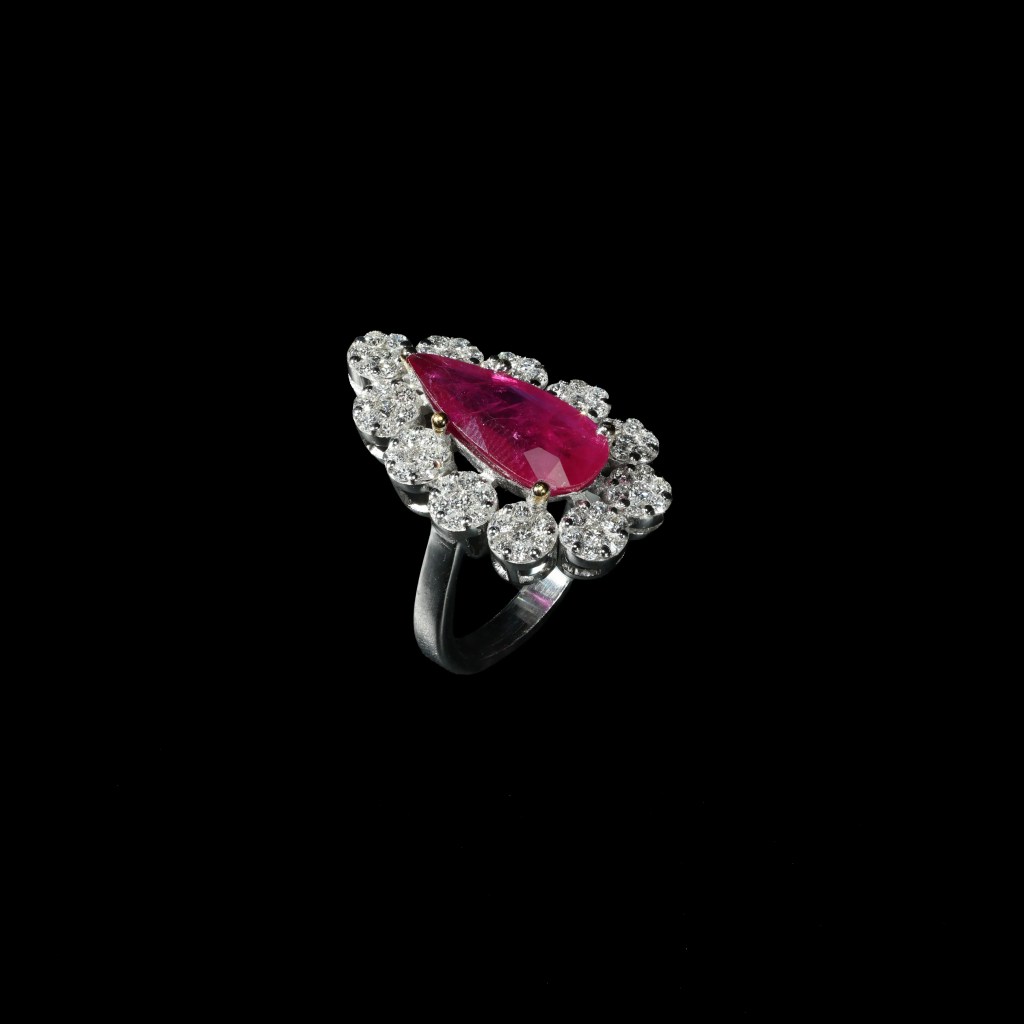 18K white gold ring with pear-shaped ruby and brilliant diamond halo.