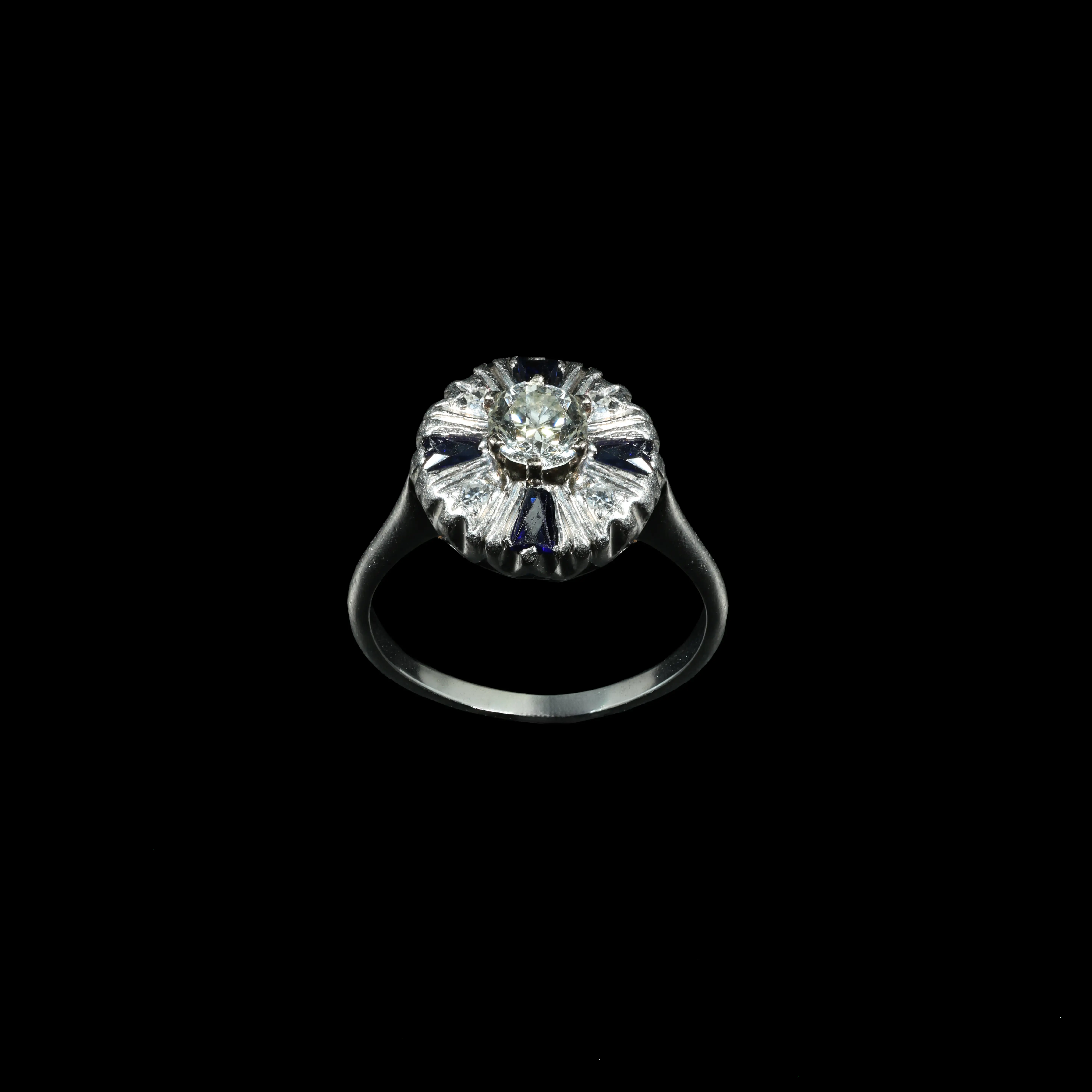 Platinum vintage ring with Old European cut diamond and blue tapered baguette sapphire accents.