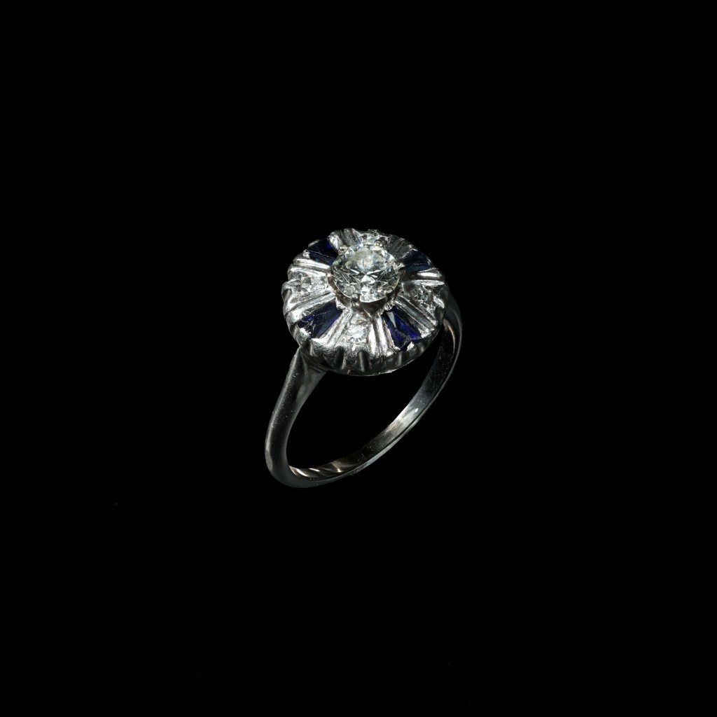 Platinum vintage ring with Old European cut diamond and blue tapered baguette sapphire accents.